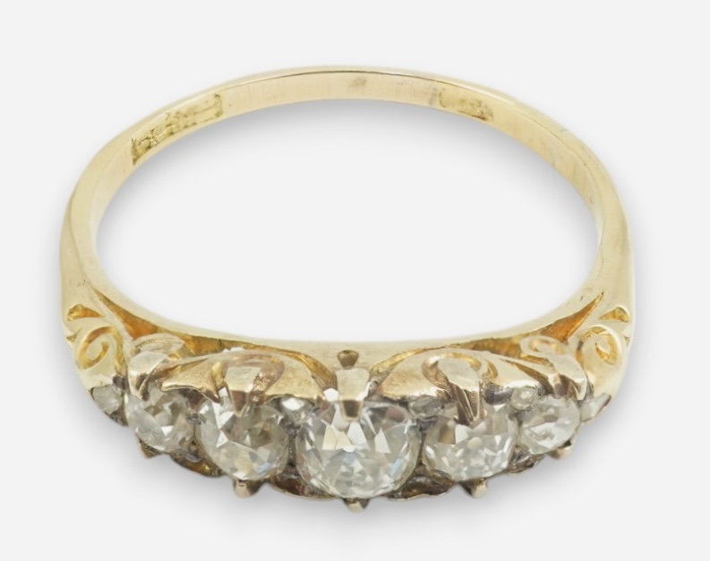 An early 20th century gold and graduated five stone old cut diamond set half hoop ring